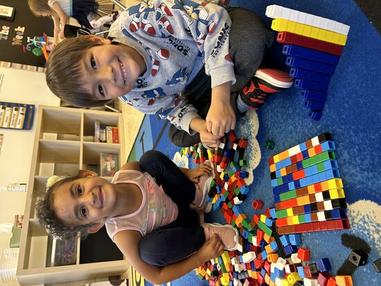 Kindergarten children smiling and playing with blocks together